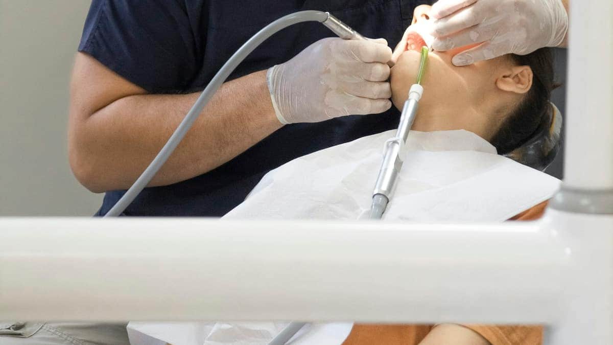 Chirurgien-dentiste soignant une patiente au fauteuil
